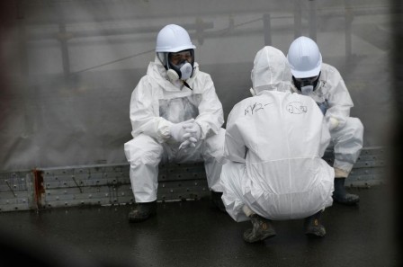 698183-workers-wearing-radiation-protective-gear-rest-on-a-road-at-tepco-s-tsunami-crippled-fukushima-daiic.jpg